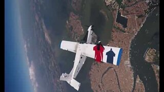 Skydivers soar dangerously close to the side of an airplane