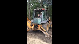 Kid driving a back hoe