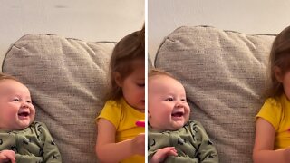 Baby boy preciously smiles at his big sister
