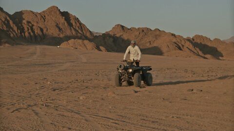 A Man Driving a Quad Bike in the Desert