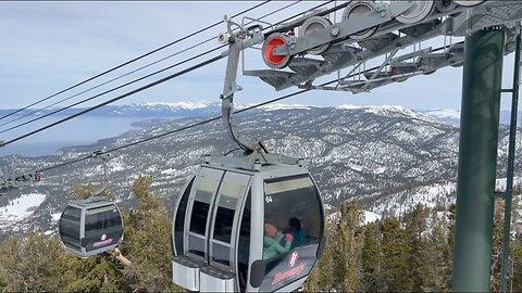 View of Lake Tahoe from the top of Heavenly Gondola sightseeing peak; cable car moving.