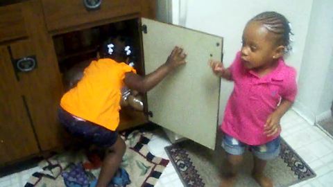 Toddlers have adorable kitchen cupboard fight