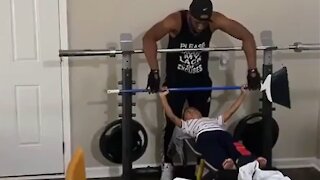 Little boy learns how to bench press at the gym