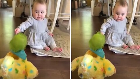 Baby utterly shocked at toy hen laying eggs