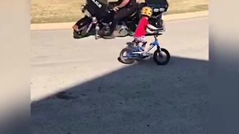 Police Officer on Motorcycle and Little Boy on Bike Circle Each Other