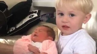 Un petit garçon de 2 ans rencontre sa petite sœur pour la première fois