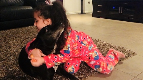 Little girl preciously paints her doggy's nails
