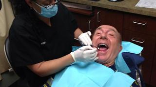 Boy films his father at the dentist.