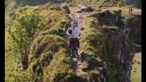 Morning Bagpipes On The Edge of a Cliff In The Scottish Highlands - HaloRockNews