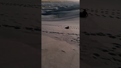 Sledding Down A Sandy Hill In Colorado Sand Dunes Park