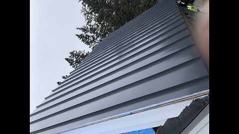 Roofing work. Power seamer on standing seam roof project .