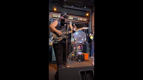 Man drinks beer while playing guitar