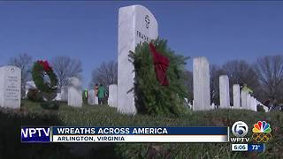 Volunteers place wreaths on tombstones at Arlington National Cemetery