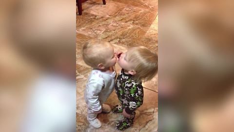 "A Tot Girl Kisses Her Baby Brother on Command"