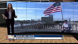 Man on I-84 overpass holds American flag to honor veterans