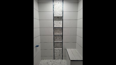 Custom bathroom, tile ceiling, waterfall feature, glass, pebbles, schluter strip