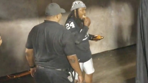 LOL! Marshawn Lynch Eats Chicken Wings While Walking onto the Field for Preseason Game