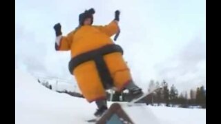 Desportistas praticam snowboard com fatos de sumo