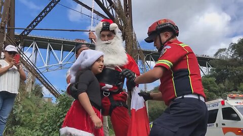 Santa firefighter rappels gifts down a bridge for Guatemalan kids