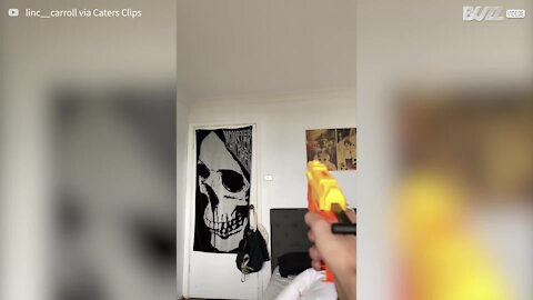 Young man hits fly with Nerf gun