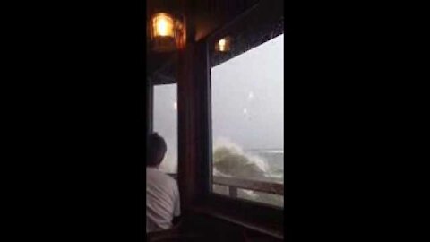 Huge wave breaks through restaurant window