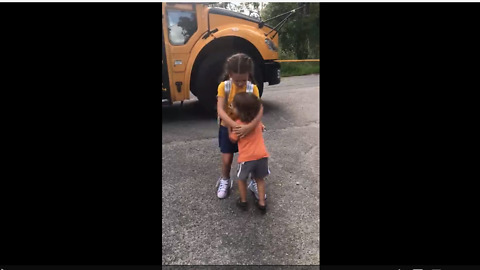 Cute kid hugs sister when she gets off school bus