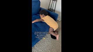 Baby holding onto couch for his life in fear of falling