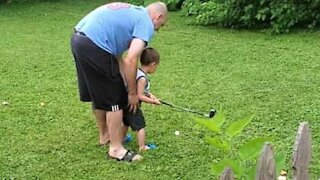 Kid gets frustrated learning golf and kicks the ball
