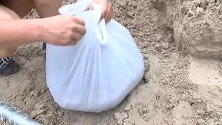 Residents improvise when sandbags run out to protect their homes | Digital Short