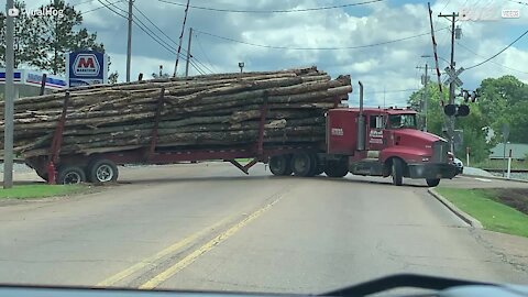 Truck jackknifes and spills logs across highway