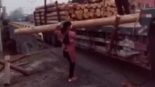 Tiny woman carries gigantic tree trunk!