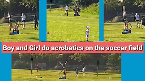 Boy and girl do acrobatics on the soccer field