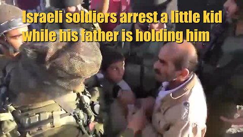 Israeli soldiers arrest a little kid while his father is holding him