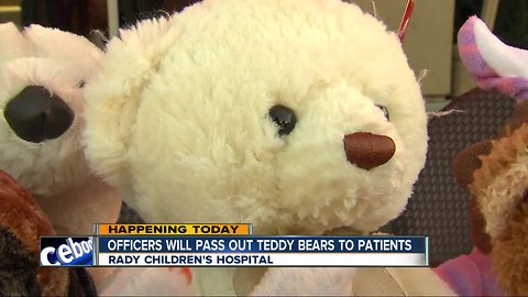 Local law enforcement officers handing out teddy bears at Rady Children's Hospital