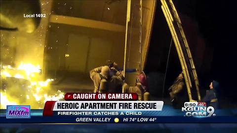 Firefighter catches child escaping from apartment fire