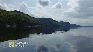 Boating along glassy water on a partly cloudy day