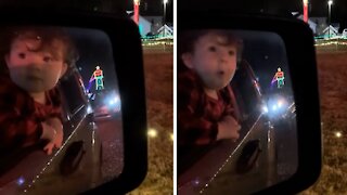 Surprised toddler in awe of Christmas lights display