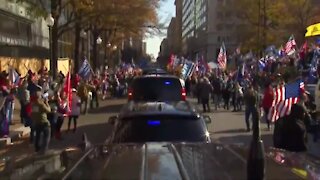 Trump thrills protesting supporters with motorcade drive-by