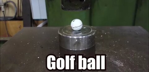 Crushing golf ball with hydraulic press.