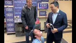 Andrew Yang sprays whipped cream in kneeling supporter's mouth