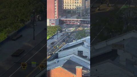 hundreds of dirt bikes and ATVs with other vehicles, driving through the downtown part of Rochester