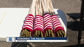 Volunteers place flags on gravestones for Memorial Day