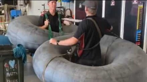 Employees of tire shop use tires for social distancing