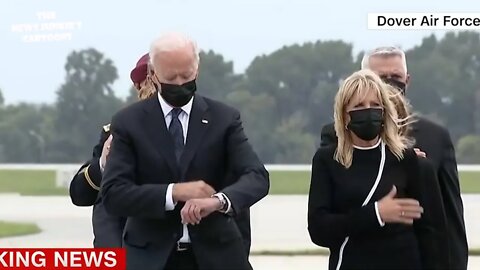 Biden checks his watch while participates in dignified transfer at Dover Air Force Base.
