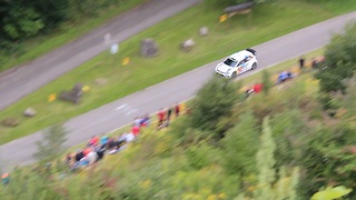 Rally car leader crashes through hillside barrier