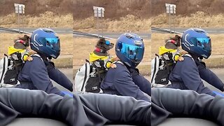 Dog rides on his owner's back on the motorcycle.