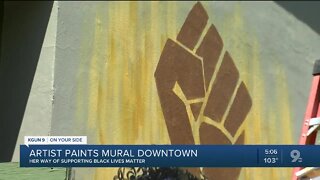 Artist paints mural downtown