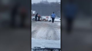 Cuyahoga County Public Works employees help person in wheelchair stuck in snow