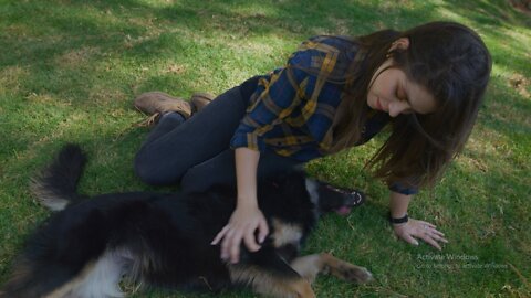 Woman petting her dog on the grass.
