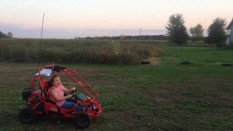 A Girl Drives A Go-Cart And Crashes Into A Cornfield